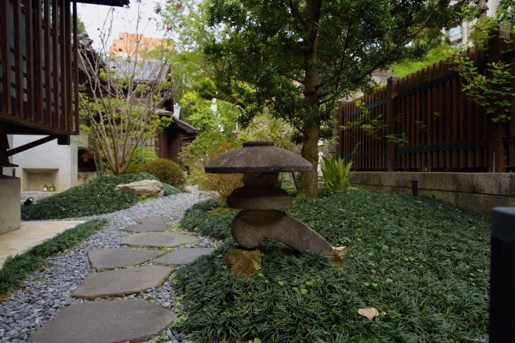 Tranquil stone path and lantern in a lush Japanese garden in Taipei.